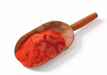 Heap of paprika powder on a wooden scoop