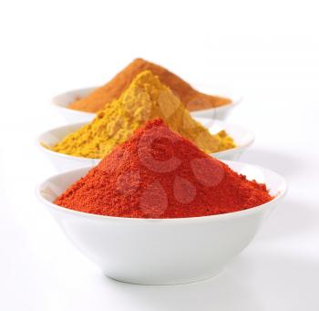 Bowls of curry powder, paprika and ground cinnamon