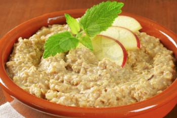 Bowl of white oats porridge with fresh apple