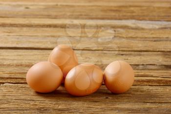 Fresh brown eggs on wooden surface