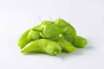 Group of raw green peppers on white background
