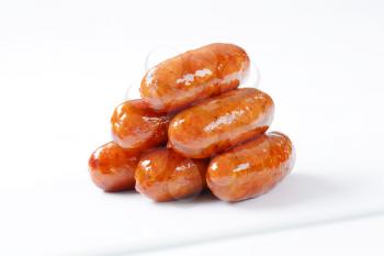 stack of pan fried sausages on white background