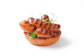 bowl of grilled sausages with parsley and rosemary