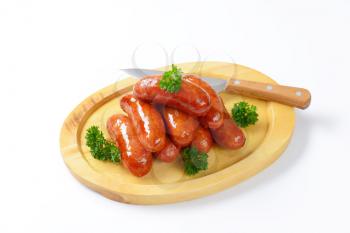 stack of pan fried sausages on cutting board