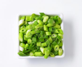 Chopped spring onions in square bowl