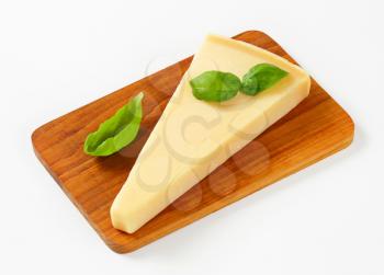 Wedge of Parmesan cheese on cutting board