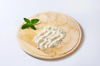 Soft wheat flour on round wood board
