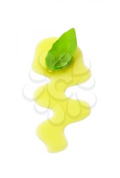 Olive oil drizzle and fresh basil leaf isolated on white