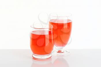Two glasses of red fruit flavored drinks