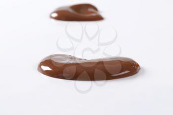 blobs of chocolate pudding on white background