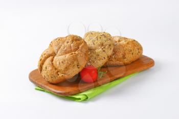 fresh Kaiser rolls on wooden cutting board