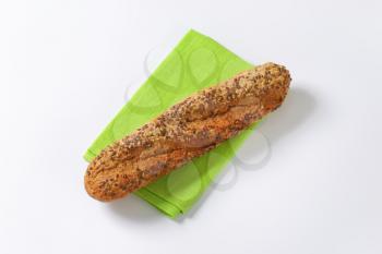 fresh baguette bread with seeds on green place mat