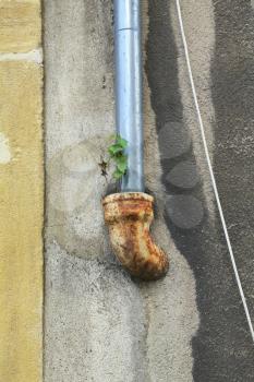 rusty drain pipe on a wet wall