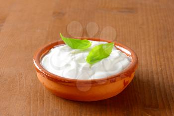 white yogurt or sour cream in a ceramic bowl