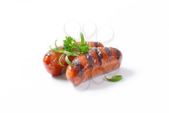 two grilled sausages on white background