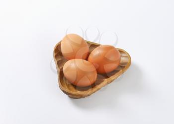 bowl of organic eggs on white background