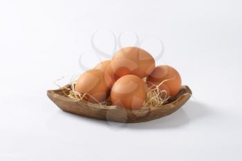 fresh brown eggs in wooden bowl