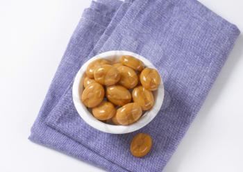 bowl of caramel candies on blue tablecloth