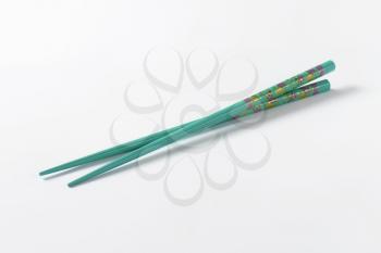 A pair of blue chopsticks with floral pattern