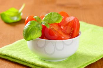 Bowl of halved fresh red plum tomatoes