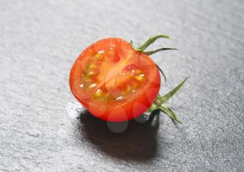 half a red tomato on slate
