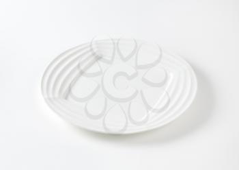 Modern white plate with ridges on the rim