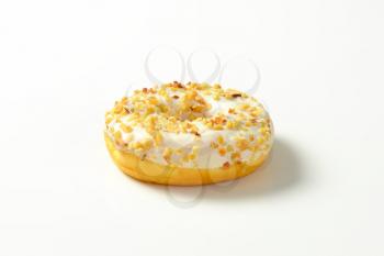 Glazed donut topped with chopped nuts