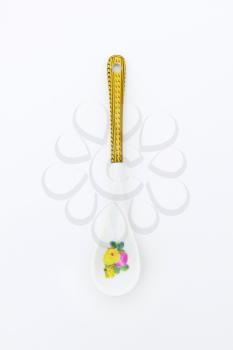 White spoon with floral and ornate print