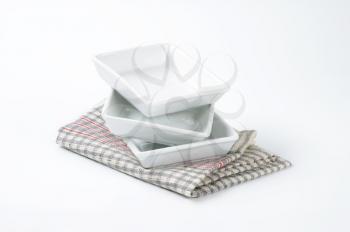 Stack of three ceramic rectangular white deep plates or baking dishes