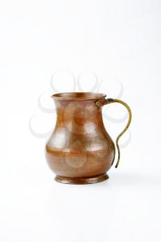 old hammered copper pitcher with brass handle