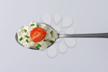 spoon of fresh cottage cheese with chives
