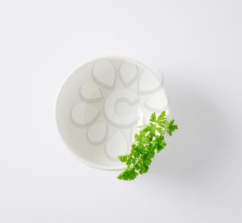 sprig of fresh parsley in white bowl