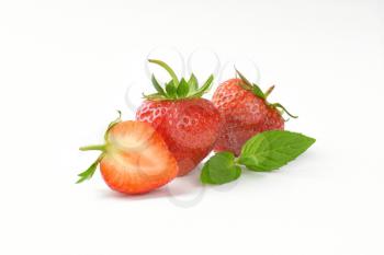 two and half fresh strawberries on white background