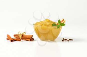 bowl of apple sauce and spice on white background