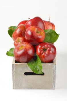 box of red apples on white background