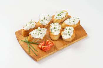 small slices of toasted baguette with cheese spread