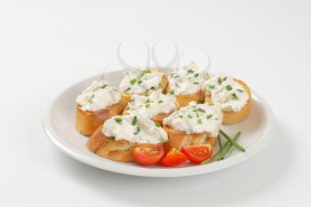 small slices of toasted baguette with cheese spread