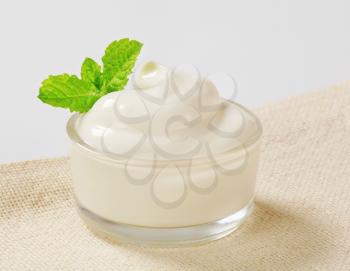 Swirl of smooth white cream in a small glass bowl
