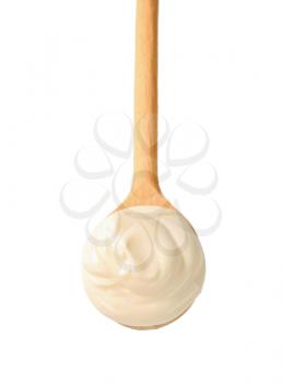 Sour cream on a wooden spoon isolated on white