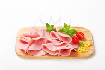 Thin slices of ham on cutting board