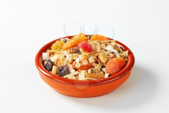 Bowl of rolled oats with various dried fruit pieces and nuts