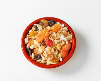 Bowl of rolled oats with various dried fruit pieces and nuts