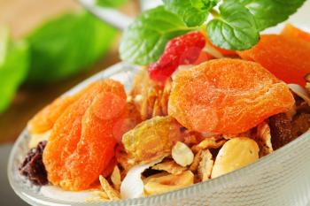 Bowl of rolled oats with various dried fruit pieces and nuts