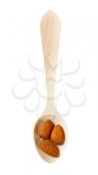 three raw almonds on small wooden spoon isolated on white