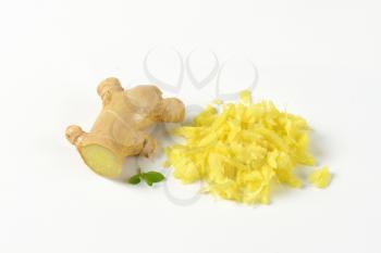 whole and grated fresh ginger on white background