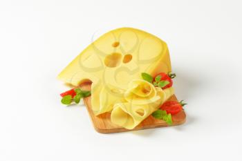 Swiss type cheese on wooden cutting board