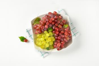 bowl of red and white grapes on checkered dishtowel
