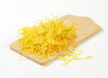 Heap of dried egg soup noodles on cutting board