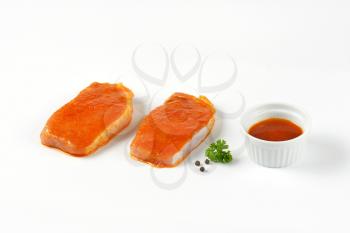 raw honey glazed pork chops on white background