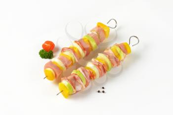 Two raw pork and vegetable skewers